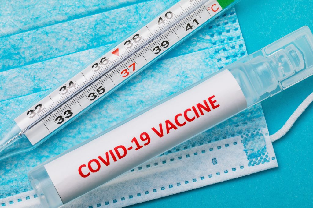 COVID-19 new coronavirus vaccine, thermometer and medical mask