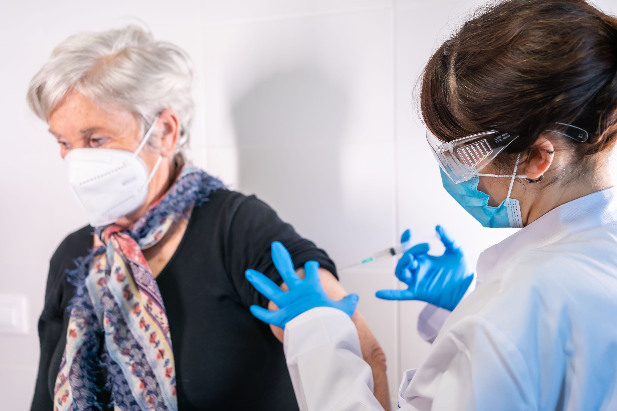 An elderly woman receiving the injection of the coronavirus vaccine by a doctor to receive the antibodies, immunize the population. side effects, risk people, antibodies, new normal, covid-19