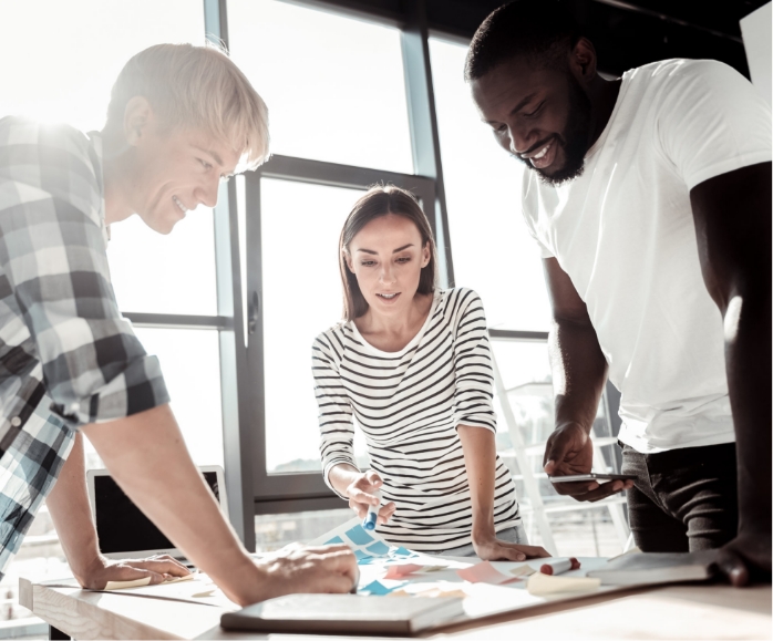 two men and one woman working together on a project.